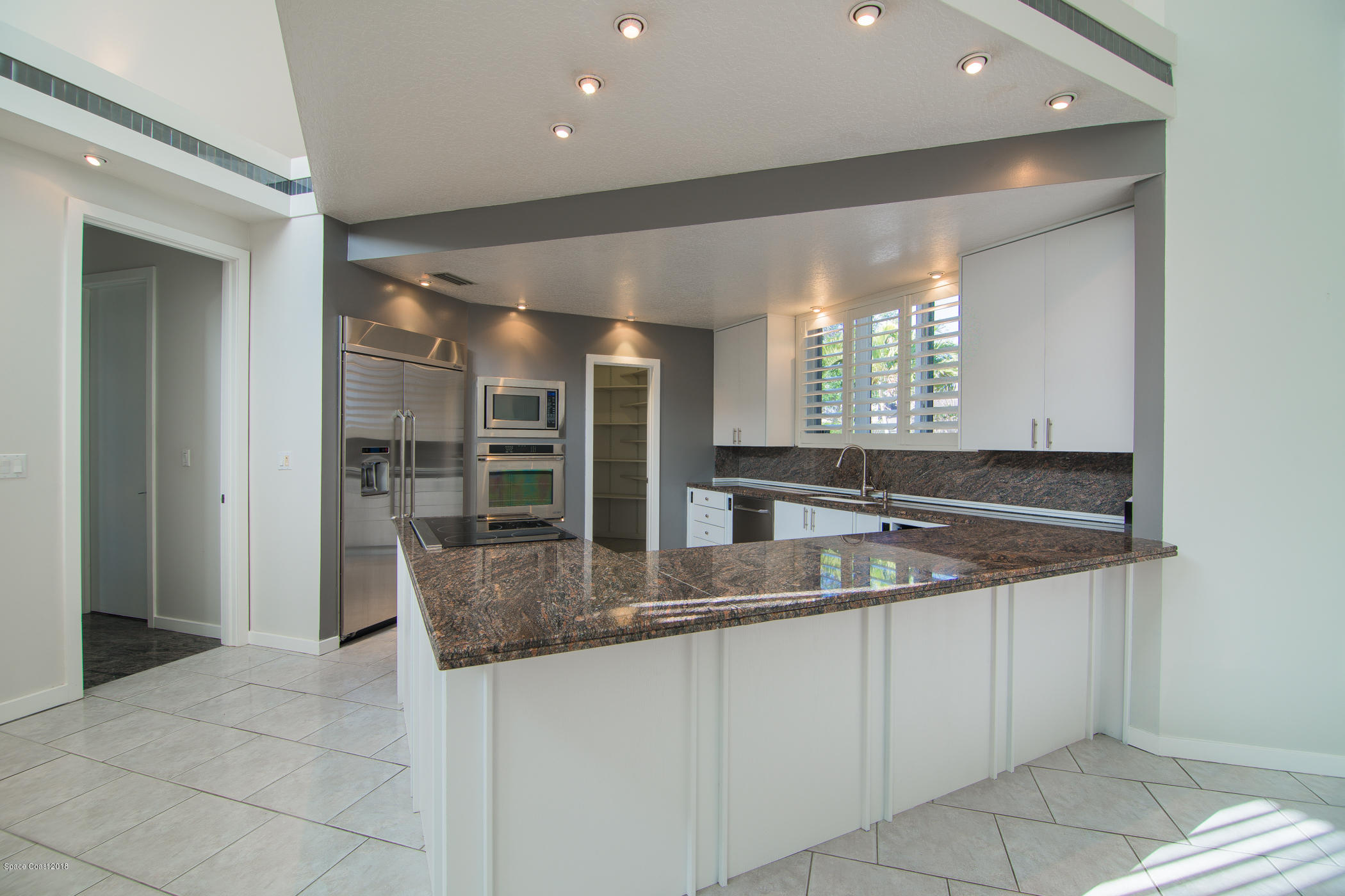 3081 Rio Baya North Melbourne, FL 32903 - Photo 14 of 31 a kitchen with stainless steel appliances granite countertop a sink and a large mirror