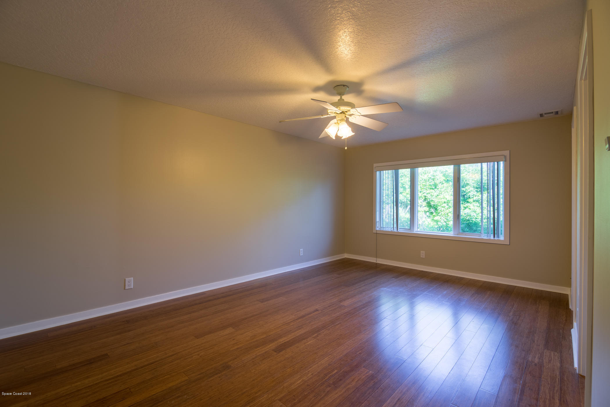 3081 Rio Baya North Melbourne, FL 32903 - Photo 17 of 31 a view of an empty room with wooden floor and a window