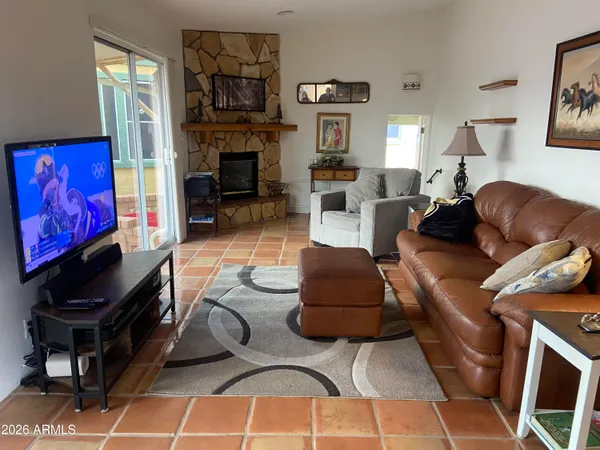 a living room with furniture a fireplace and a flat screen tv