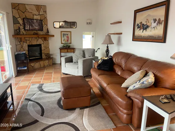 a living room with furniture a fireplace and a flat screen tv