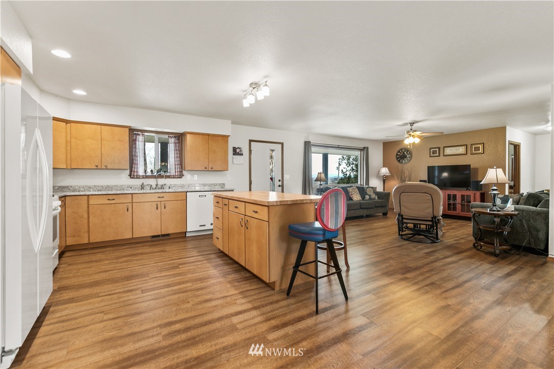 6902 Goodwin Road Everson, WA 98247 - Photo 22 of 39 a living room with furniture a dining table wooden floor and a view of kitchen