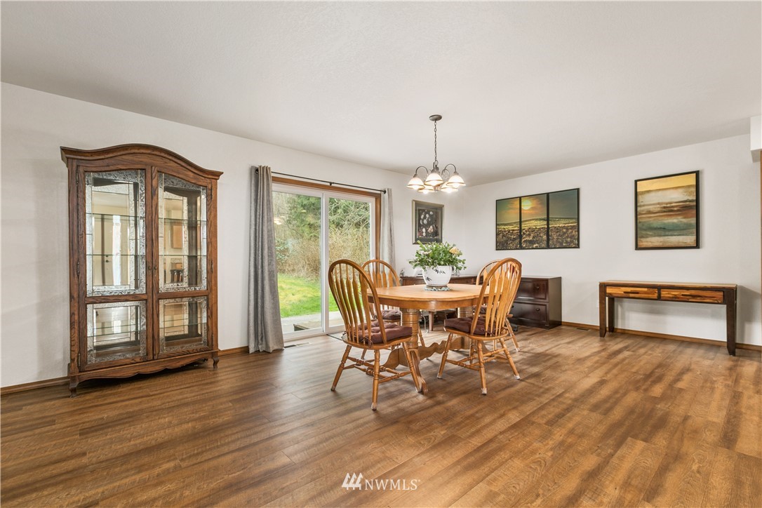 6902 Goodwin Road Everson, WA 98247 - Photo 23 of 39 a dining room with furniture a chandelier and wooden floor