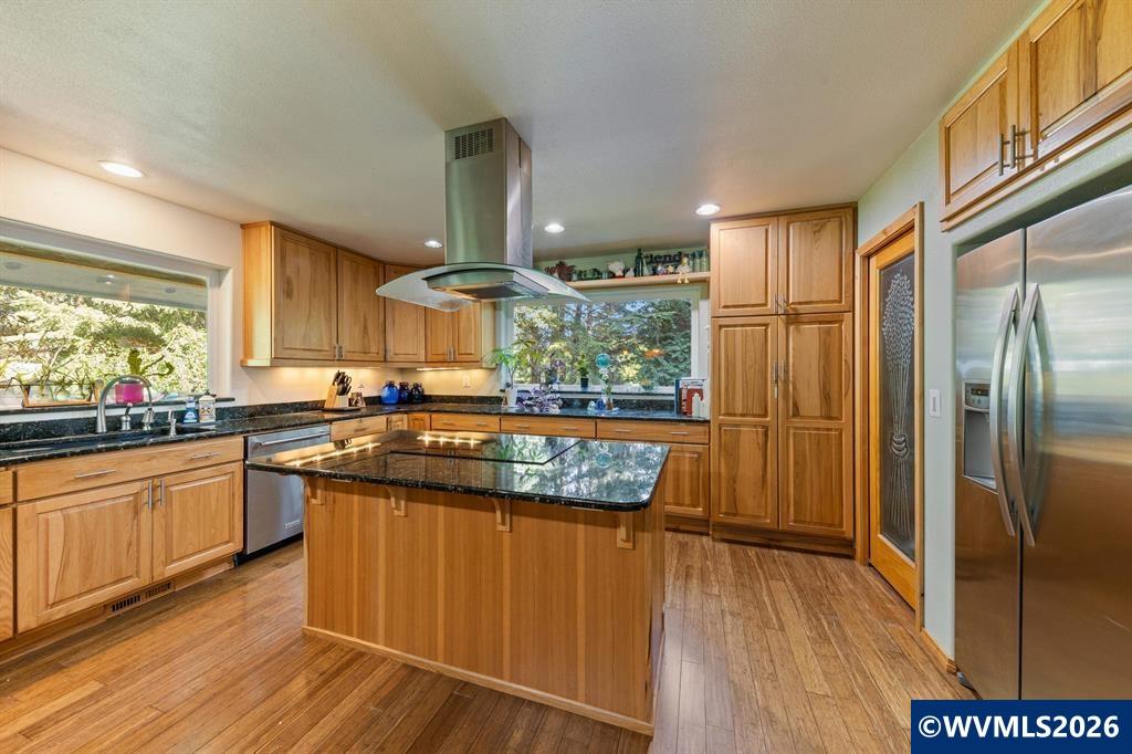 6100 Teal Creek Road Dallas, OR 97338 - Photo 12 of 41 a kitchen with stainless steel appliances granite countertop a refrigerator a sink dishwasher a stove and white countertops with wooden floor