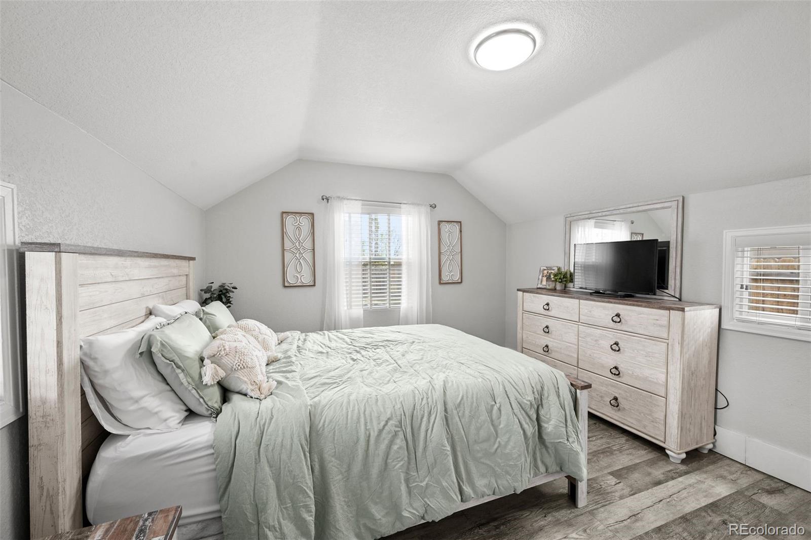 800 South Krameria Street Denver, CO 80224 - Photo 12 of 32 a bedroom with a large bed and a flat tv screen on dresser
