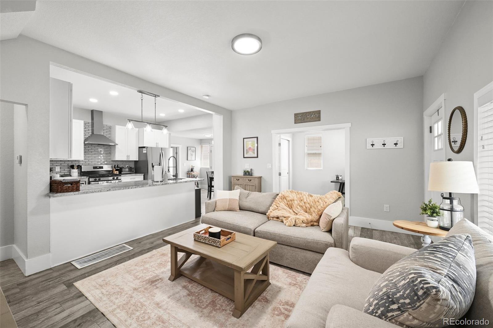 800 South Krameria Street Denver, CO 80224 - Photo 6 of 32 a living room with furniture kitchen view and a wooden floor
