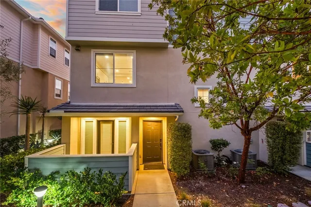 a view of a brick house with many windows next to a yard