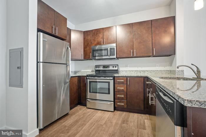 131 Bridge Street, Unit 2B22402 Phoenixville, PA 19460 - Photo 102 of 104 a kitchen with granite countertop stainless steel appliances and wooden cabinets