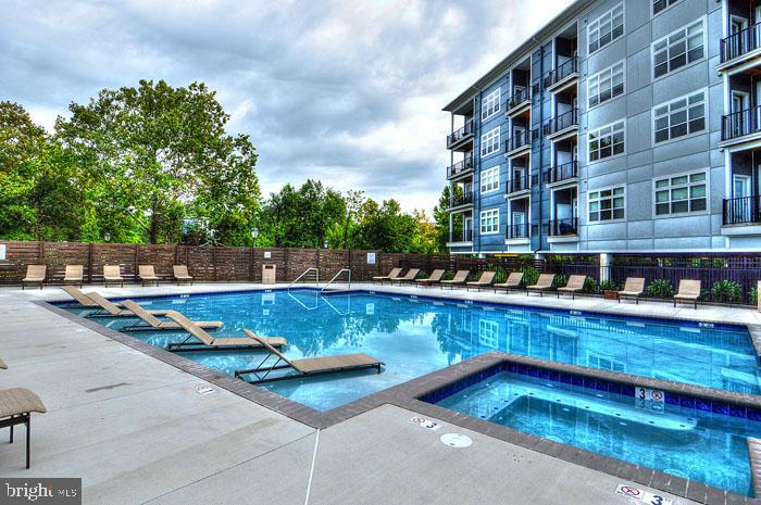 131 Bridge Street, Unit 2B22402 Phoenixville, PA 19460 - Photo 48 of 104 a view of swimming pool with outdoor seating and trees in the background