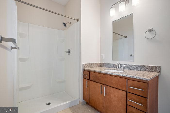 131 Bridge Street, Unit 2B22402 Phoenixville, PA 19460 - Photo 77 of 104 a bathroom with a granite countertop sink a shower and a mirror