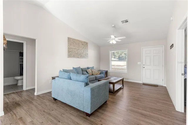 a living room with furniture and wooden floor