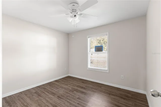 an empty room with wooden floor and window