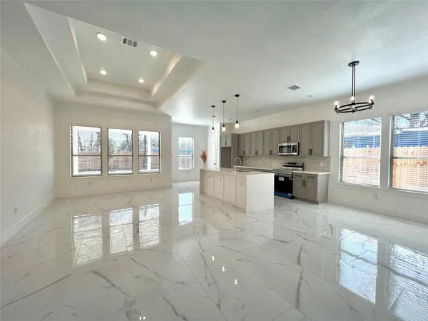 a large kitchen with stainless steel appliances kitchen island granite countertop a stove a sink a window and a dining table