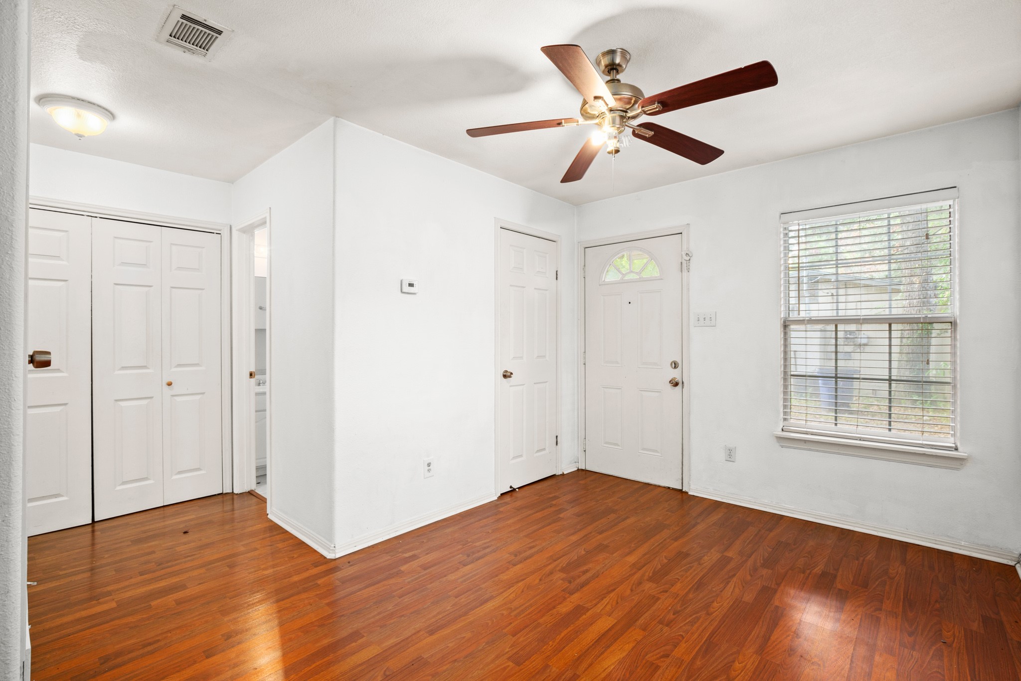 2610 East 3rd Street, Unit B Austin, TX 78702 - Photo 9 of 14 a view of an empty room with wooden floor and a ceiling fan