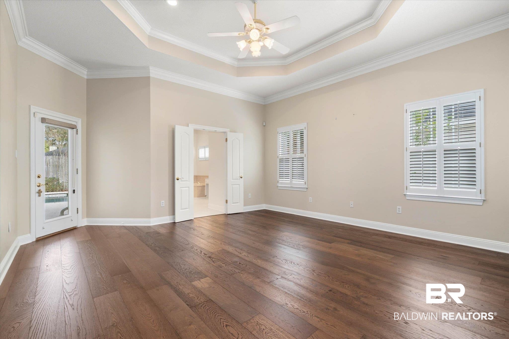 1083 Southern Way Court Mobile, AL 36609 - Photo 17 of 31 Unfurnished room with a ceiling fan, dark wood-style flooring, ornamental molding, and a tray ceiling