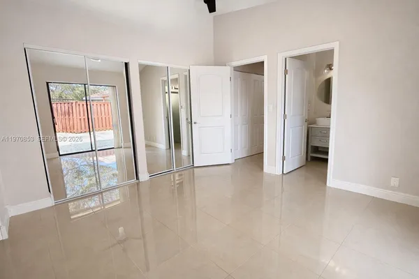 an empty room with windows and closet