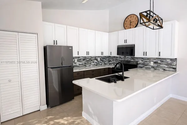 a kitchen with stainless steel appliances a refrigerator sink and stove