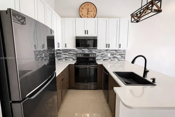 a kitchen with stainless steel appliances a stove a sink and a refrigerator