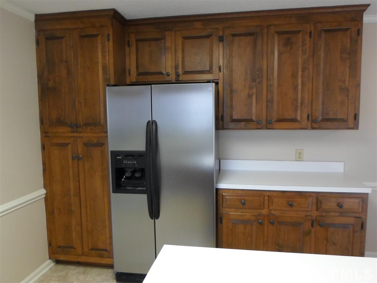 10913 Poole Road Wendell, NC 27591 - Photo 6 of 22 Nice cabinetry with pantry style cabinets to left of refrigerator. All appliances convey "as is".
