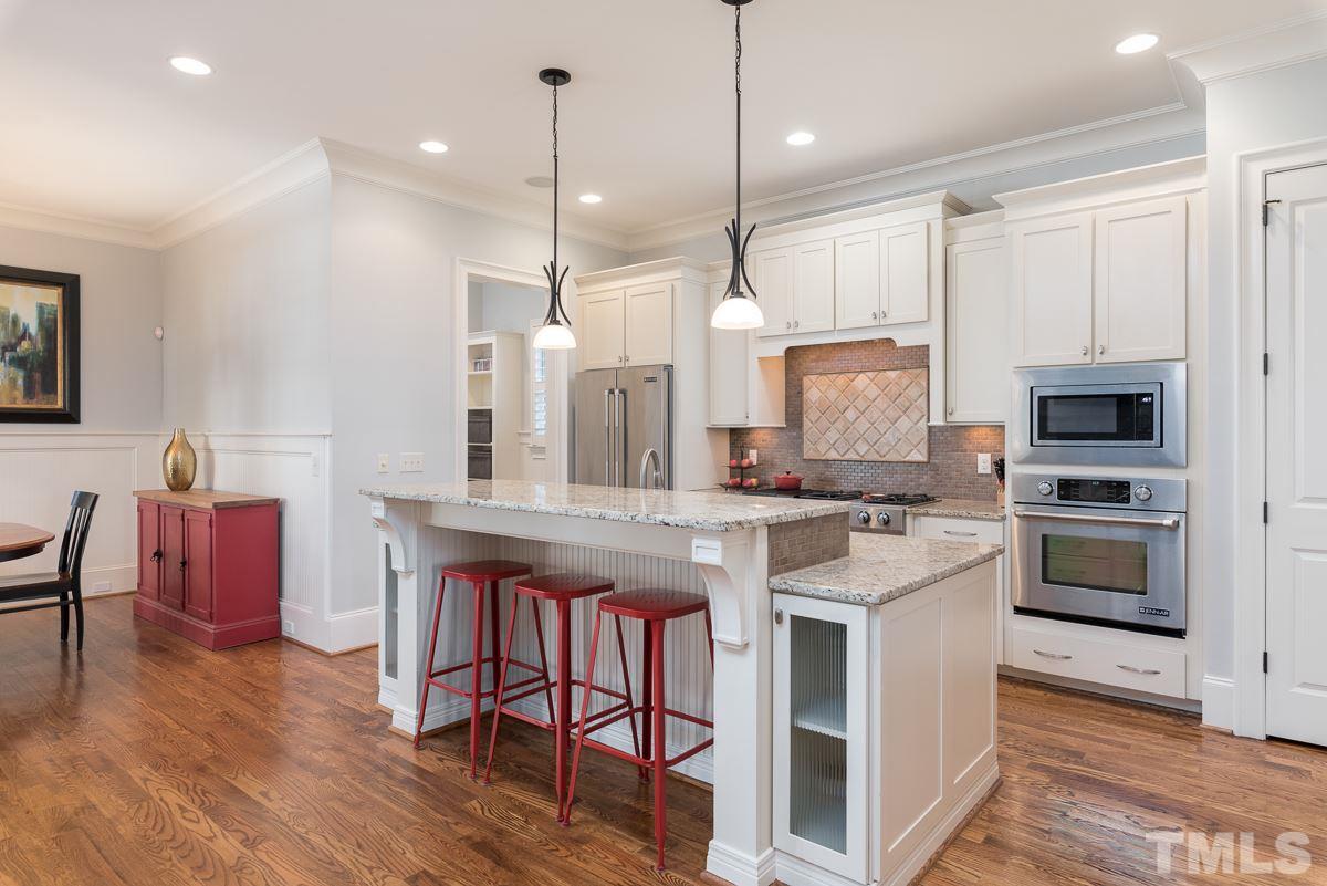 540 Guilford Circle Raleigh, NC 27608 - Photo 11 of 25 a large kitchen with stainless steel appliances kitchen island granite countertop a stove a sink a dining table and chairs