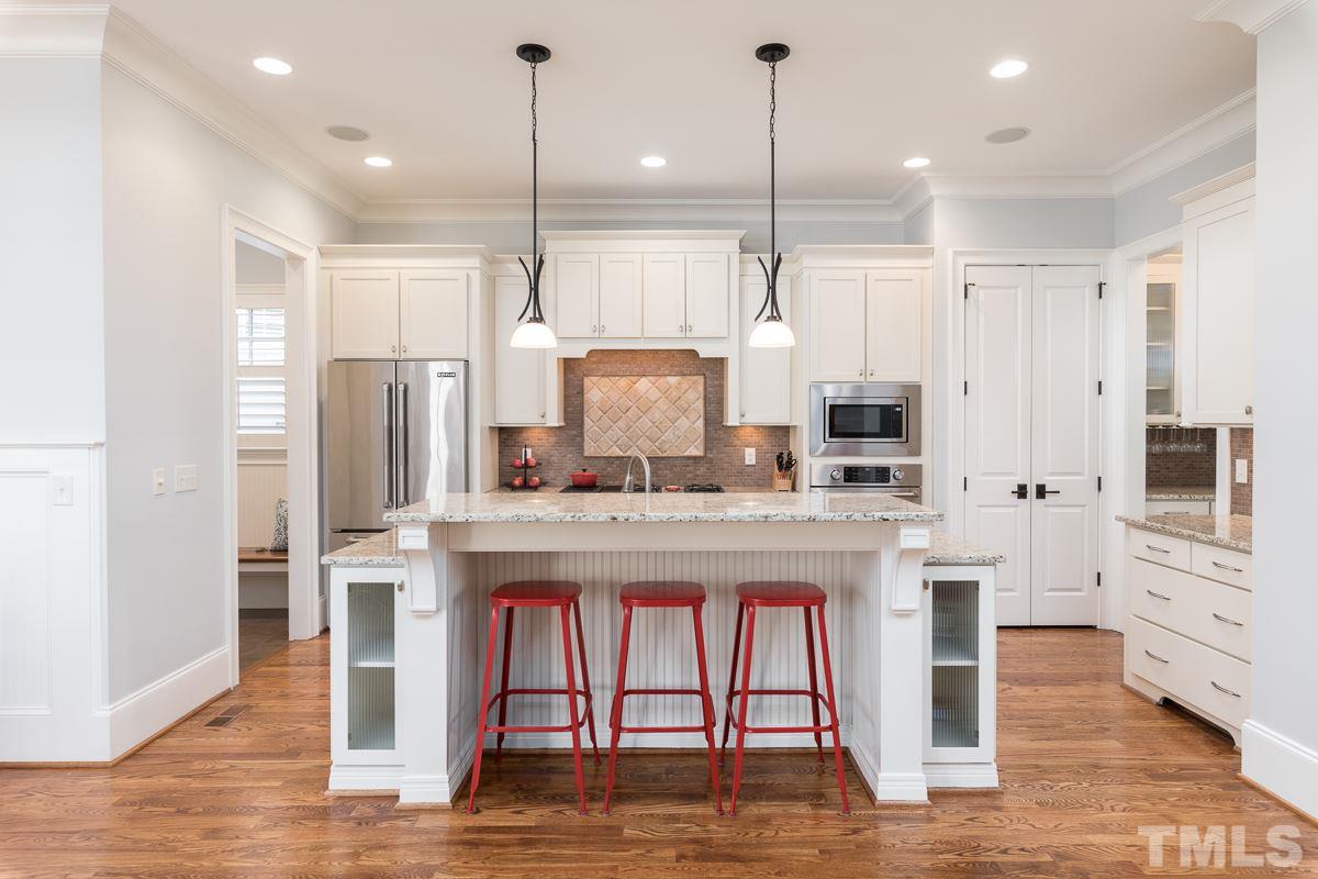 540 Guilford Circle Raleigh, NC 27608 - Photo 9 of 25 a kitchen with stainless steel appliances granite countertop a table chairs stove and refrigerator