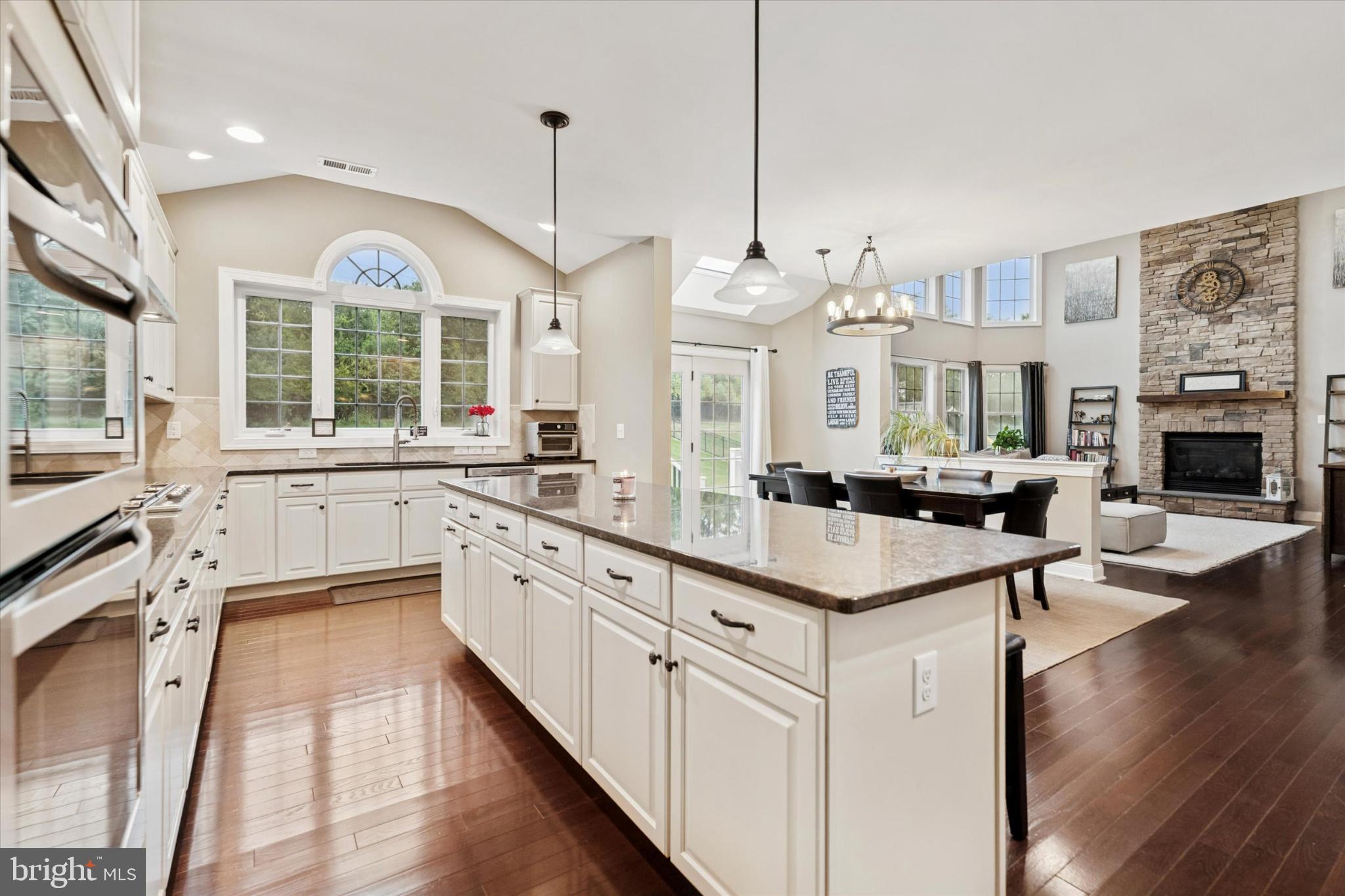 124 Bennington Road Phoenixville, PA 19460 - Photo 12 of 54 a open kitchen with stainless steel appliances granite countertop a stove top oven a sink dishwasher a dining table and chairs with wooden floor
