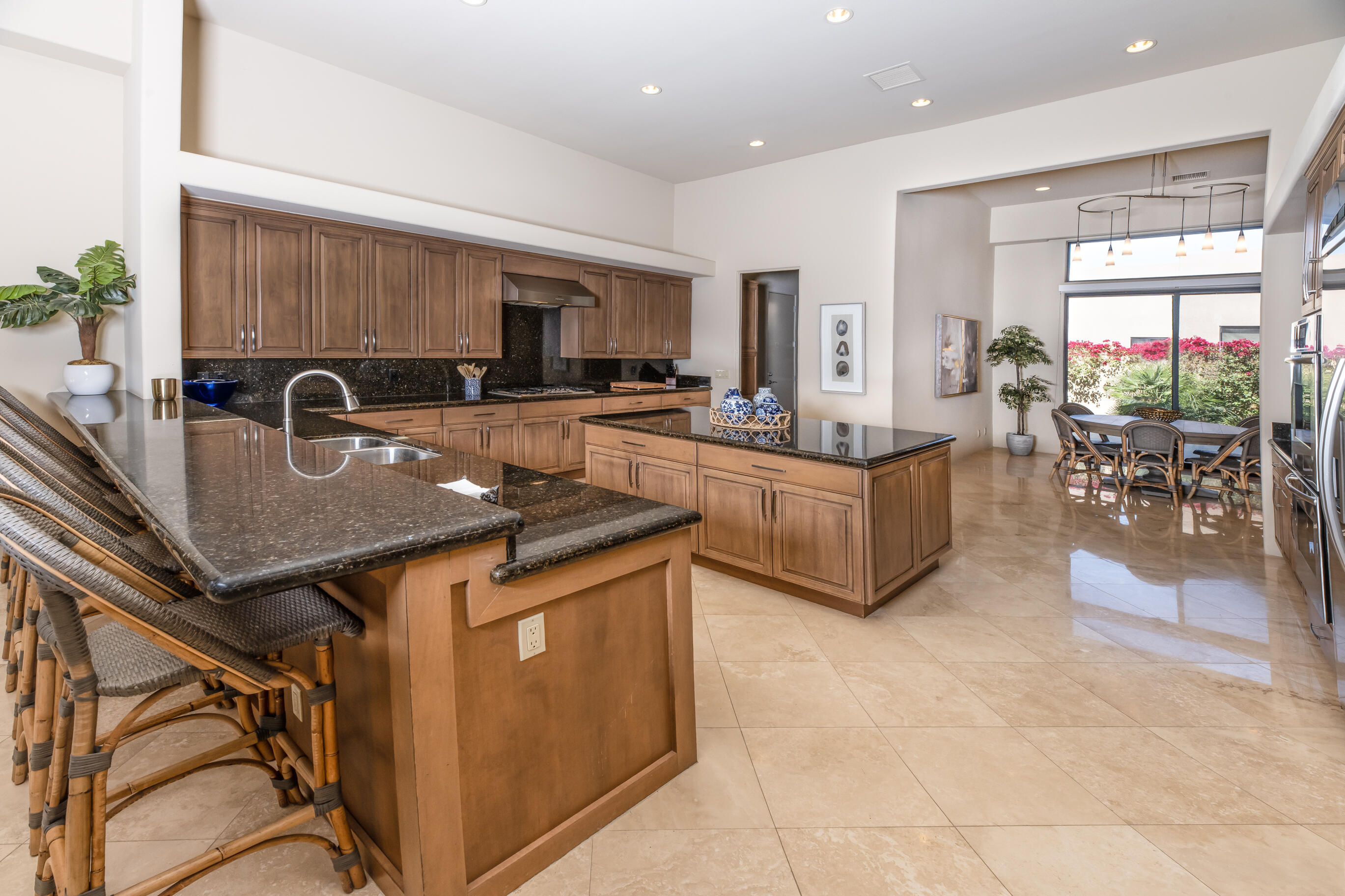 29 Sun Ridge Circle Rancho Mirage, CA 92270 - Photo 19 of 57 a living room with stainless steel appliances granite countertop a table chairs and a refrigerator