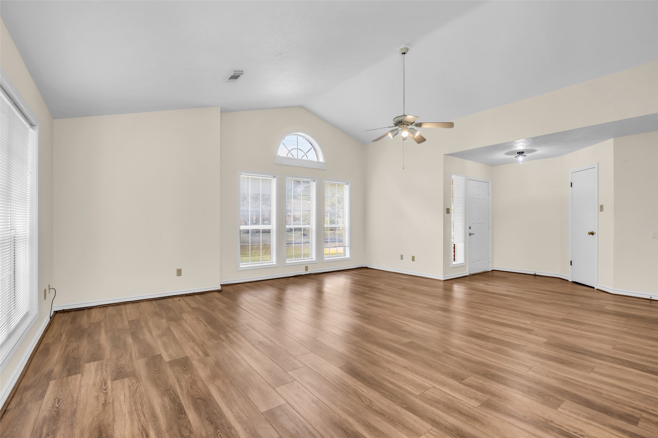 7 Lazy Spring Trinity, TX 75862 - Photo 5 of 25 Bright, open-concept living area featuring durable wood-look flooring and expansive windows that provide an abundance of natural light.