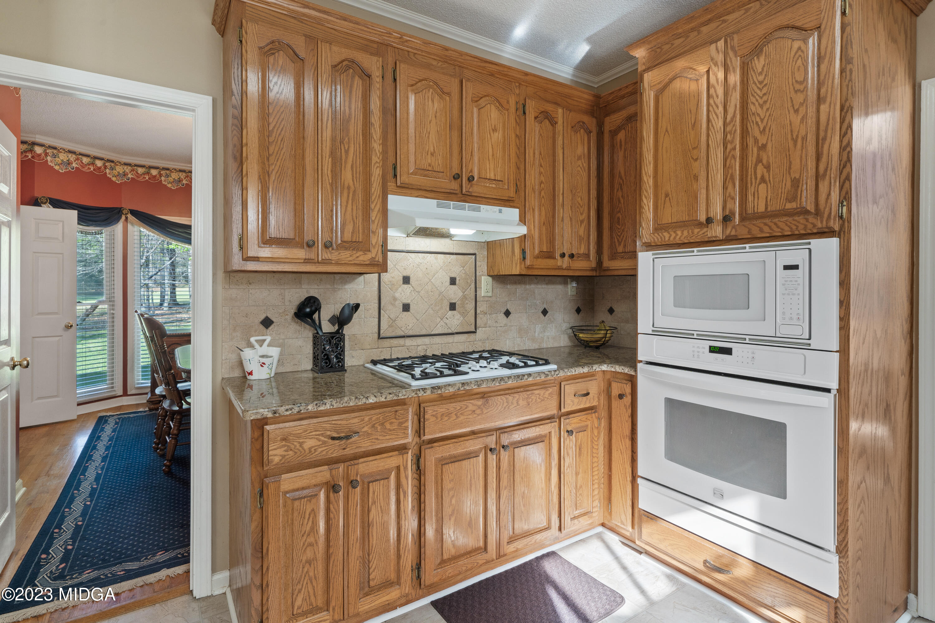 729 Sanders Road Macon, GA 31210 - Photo 7 of 29 a kitchen with stainless steel appliances granite countertop a stove a sink and a refrigerator with wooden cabinets