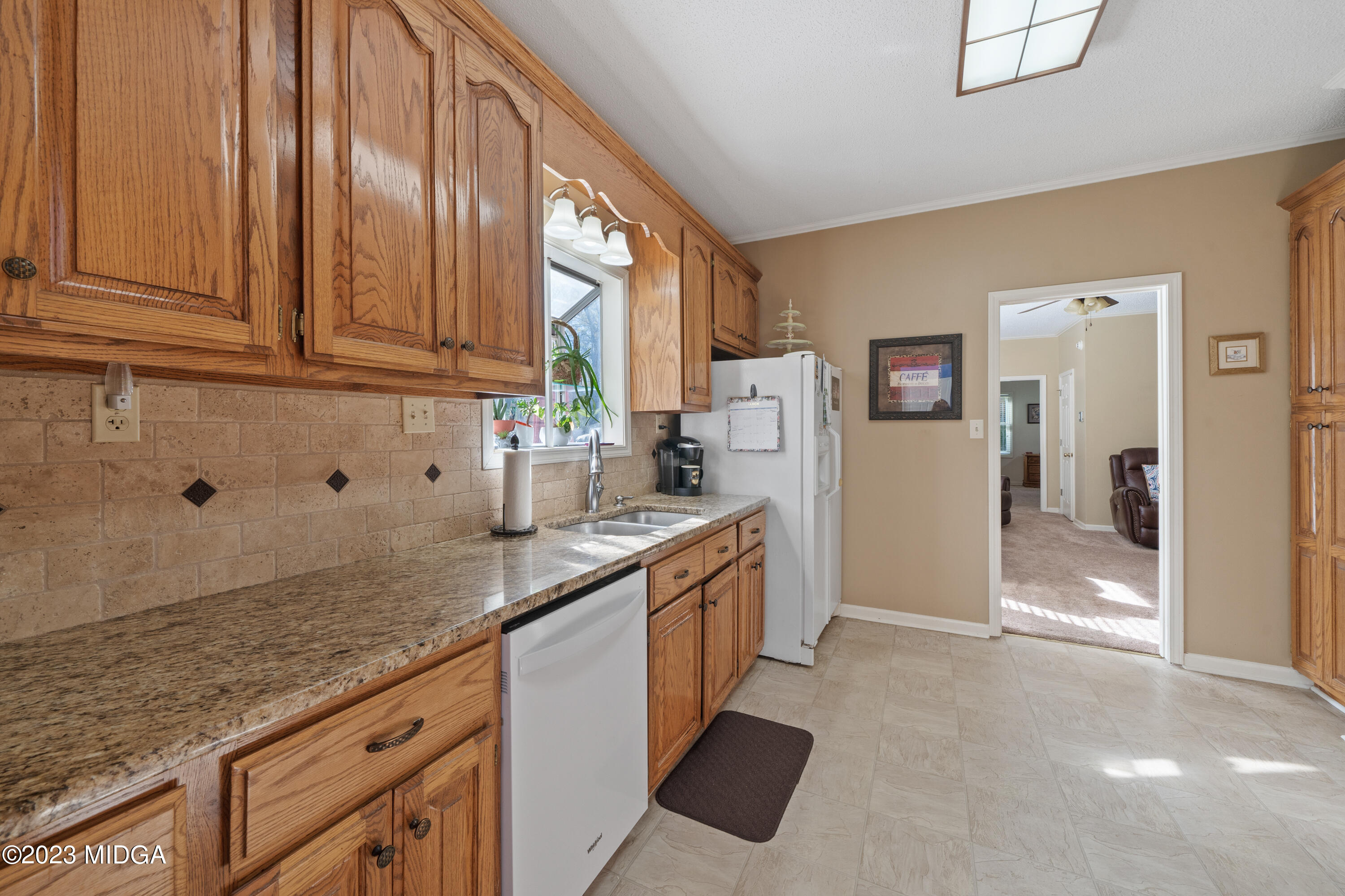 729 Sanders Road Macon, GA 31210 - Photo 8 of 29 a kitchen with granite countertop a sink stainless steel appliances white cabinets and a window