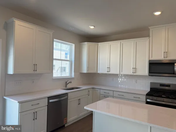 a kitchen with stainless steel appliances granite countertop a sink a stove and cabinets