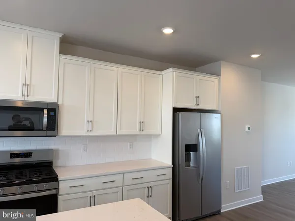 a kitchen with stainless steel appliances a refrigerator a stove a microwave and cabinets