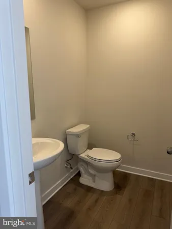 a white toilet sitting next to a white sink and vanity