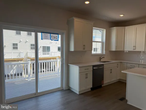 a kitchen that has a lot of cabinets in it and wooden floor