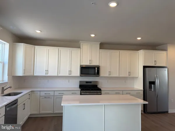 a kitchen with a refrigerator and a stove top oven