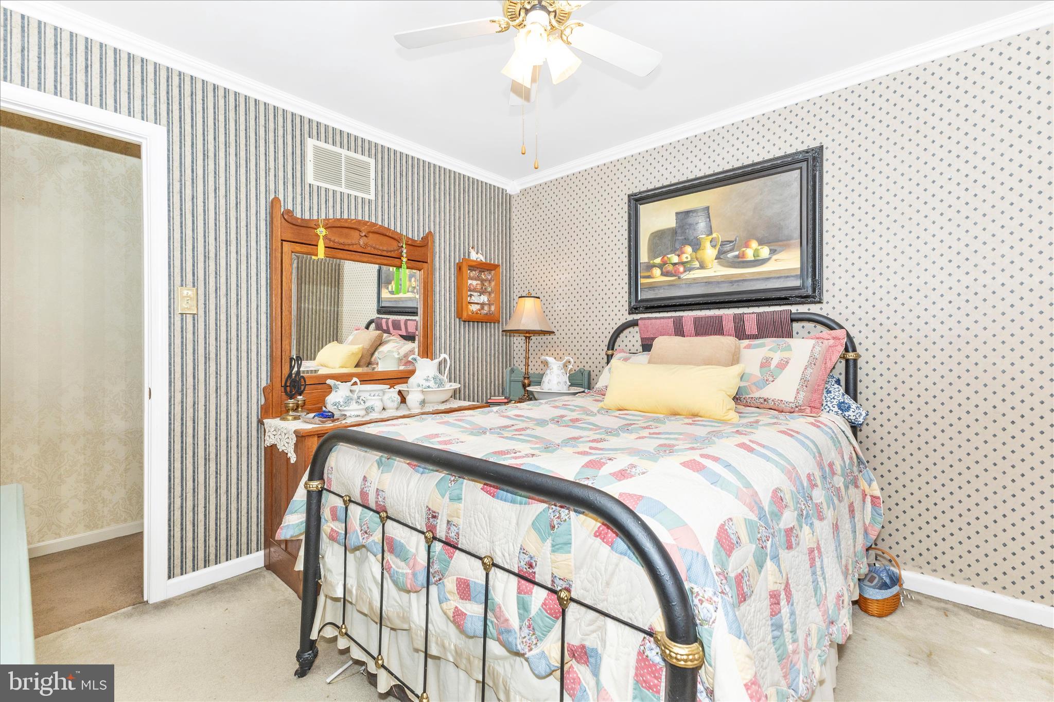 1111 Cummings Avenue Baltimore, MD 21228 - Photo 27 of 48 a bedroom with a bed and a chandelier