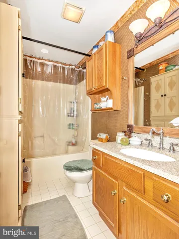 a living room with furniture and a refrigerator