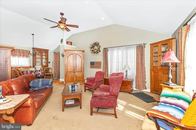 a living room with furniture kitchen view and a large window