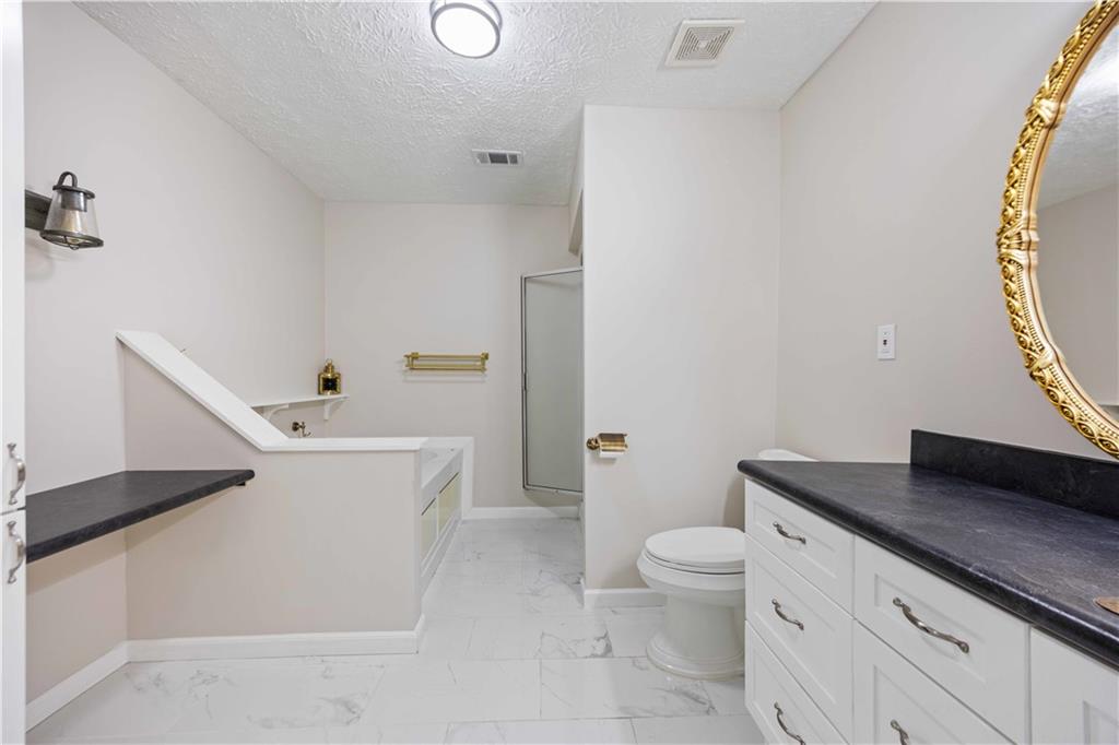 25 Gas Line Road Phenix City, AL 36870 - Photo 25 of 52 Full bathroom featuring marble look tiles, a shower with shower door, a tub to relax in, vanity, and a textured ceiling