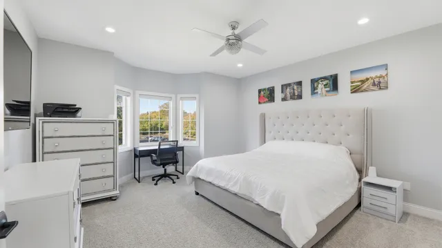 a bedroom with a large bed a table and chair