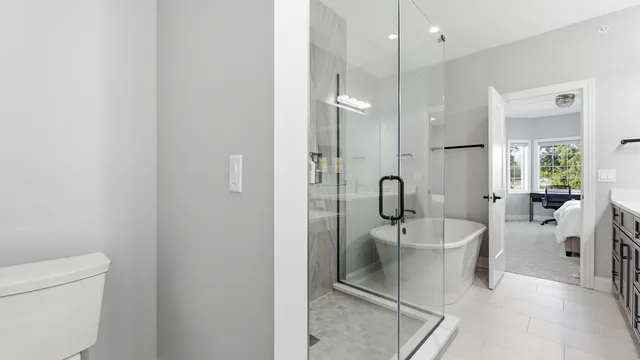 a spacious bathroom with a toilet a sink and glass door