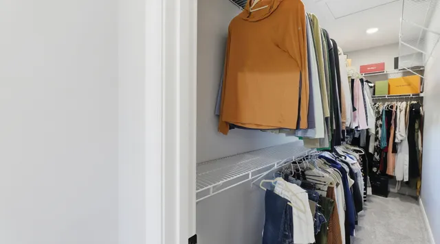 a view of walk in closet with clothes and shoes