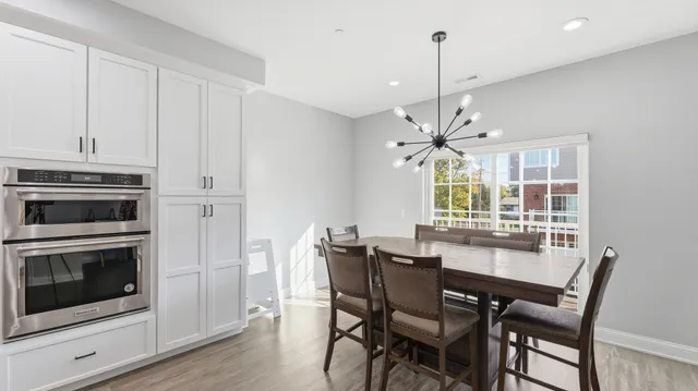 a dining room with furniture a chandelier and wooden floor