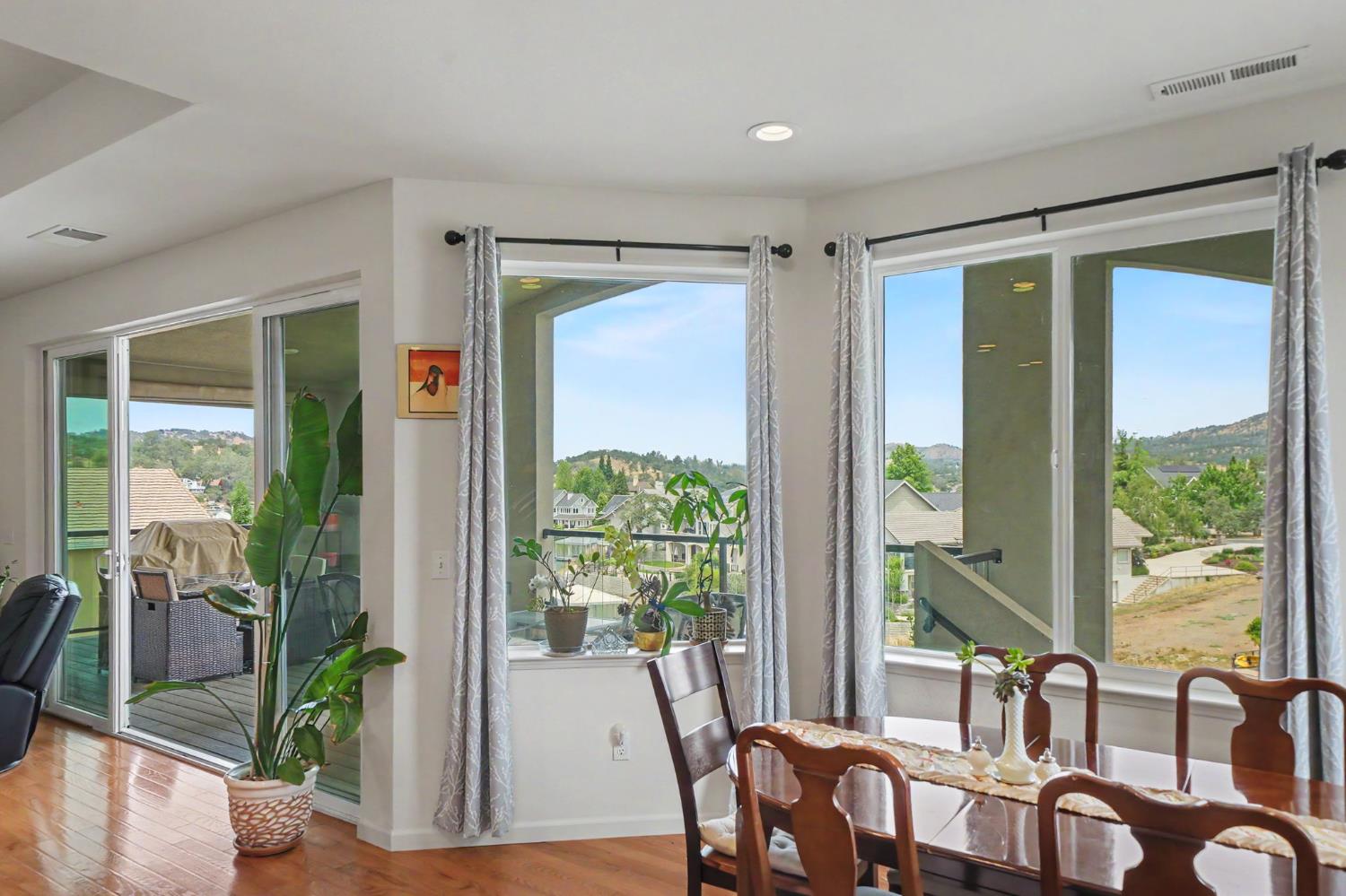6066 Bluff View Road Copperopolis, CA 95228 - Photo 36 of 96 a view of a dining room with furniture large windows and wooden floor