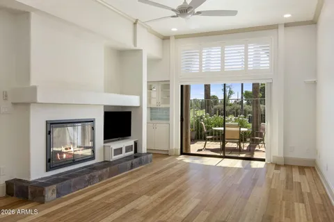 a view of a livingroom with wooden floor and a fireplace