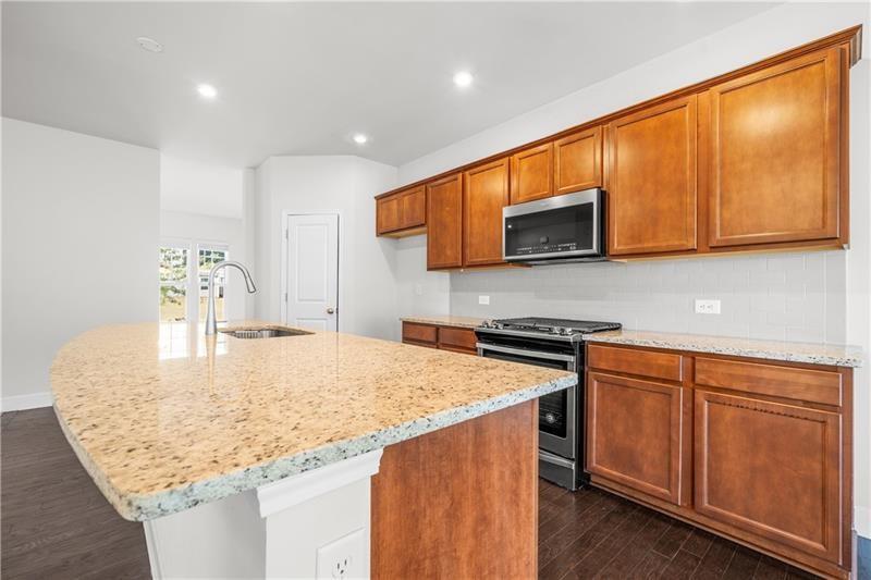 5689 Wheeler Ridge Road Auburn, GA 30011 - Photo 15 of 40 a kitchen with stainless steel appliances granite countertop a sink and microwave