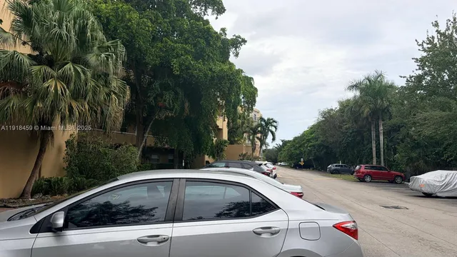 a view of parking and cars parked on the roadside