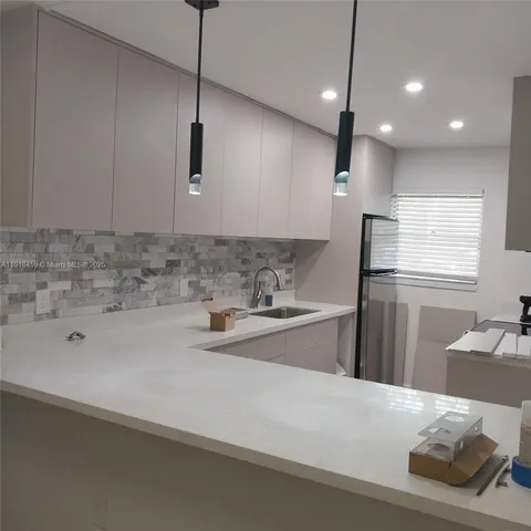 a kitchen with a sink a refrigerator and window