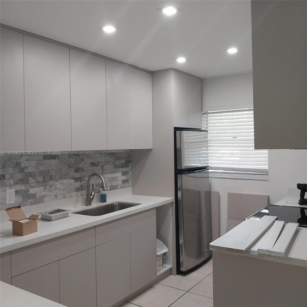 4111 Stirling Road, Unit 102 Fort Lauderdale, FL 33314 - Photo 7 of 13 a kitchen with a sink and cabinets