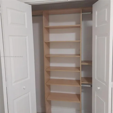 a view of walk in closet with empty racks