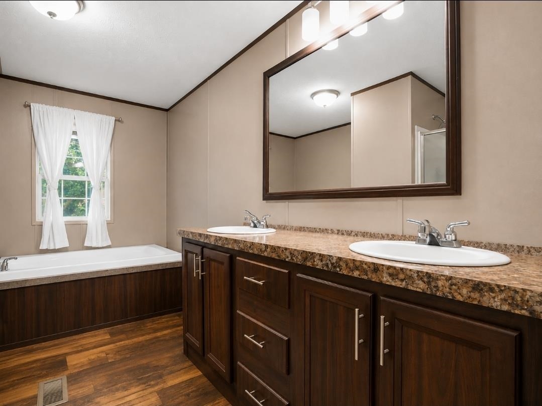 3779 Dancyville Road Stanton, TN 38069 - Photo 16 of 22 Bathroom featuring a double vanity with wood-finish cabinetry, granite-finish countertop, and undermount sinks